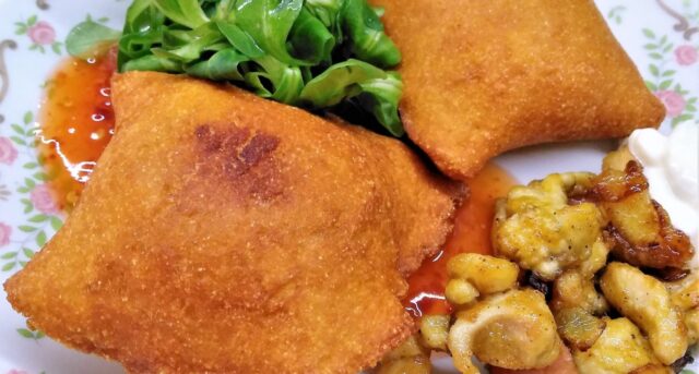 Křupavé smažené kapsy s náplní, podávané se zeleninou a dipem.