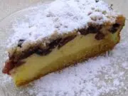 Linecký koláč s bohatou tvarohovou náplní, švestkami a skořicovou drobenkou Řez tvarohového koláče s ovocem a drobenkou, posypaný cukrem.