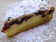 Linecký koláč s bohatou tvarohovou náplní, švestkami a skořicovou drobenkou Řez tvarohového koláče s ovocem a drobenkou, posypaný cukrem.