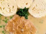 Křehké vepřové plátky na smetaně s hráškem Vepřový plátek v jemné omáčce s hráškem, podávaný s houskovým knedlíkem.