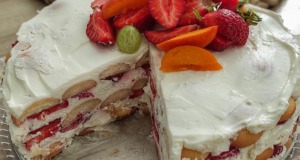Nepečený smetanový dort s jahodami a mascarpone: Osvěžující bomba, která se rozplývá na jazyku Celkový pohled na nepečený jahodový dort s bílým smetanovým krémem, bohatě zdobený čerstvými jahodami v kulaté formě.