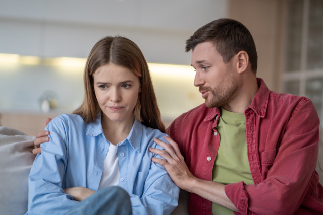 Offended girl, soothing man hug girlfriend by shoulders saying supportive words with kind expression