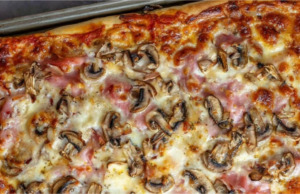 Domácí kynutá pizza na plechu se šunkou, sýrem a čerstvými žampióny